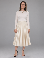 A woman modeling a cream-colored long-sleeve top and matching pleated midi skirt against a solid gray studio background.