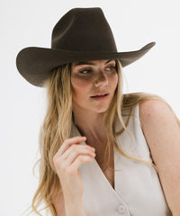 Woman wearing a brown cowboy hat against a white background