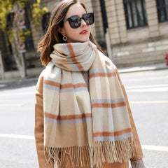 Woman wearing a large plaid scarf on a city street