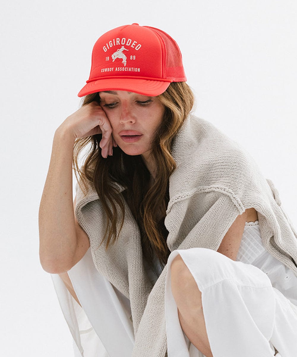 Woman wearing a red cap with text and a logo on a white background