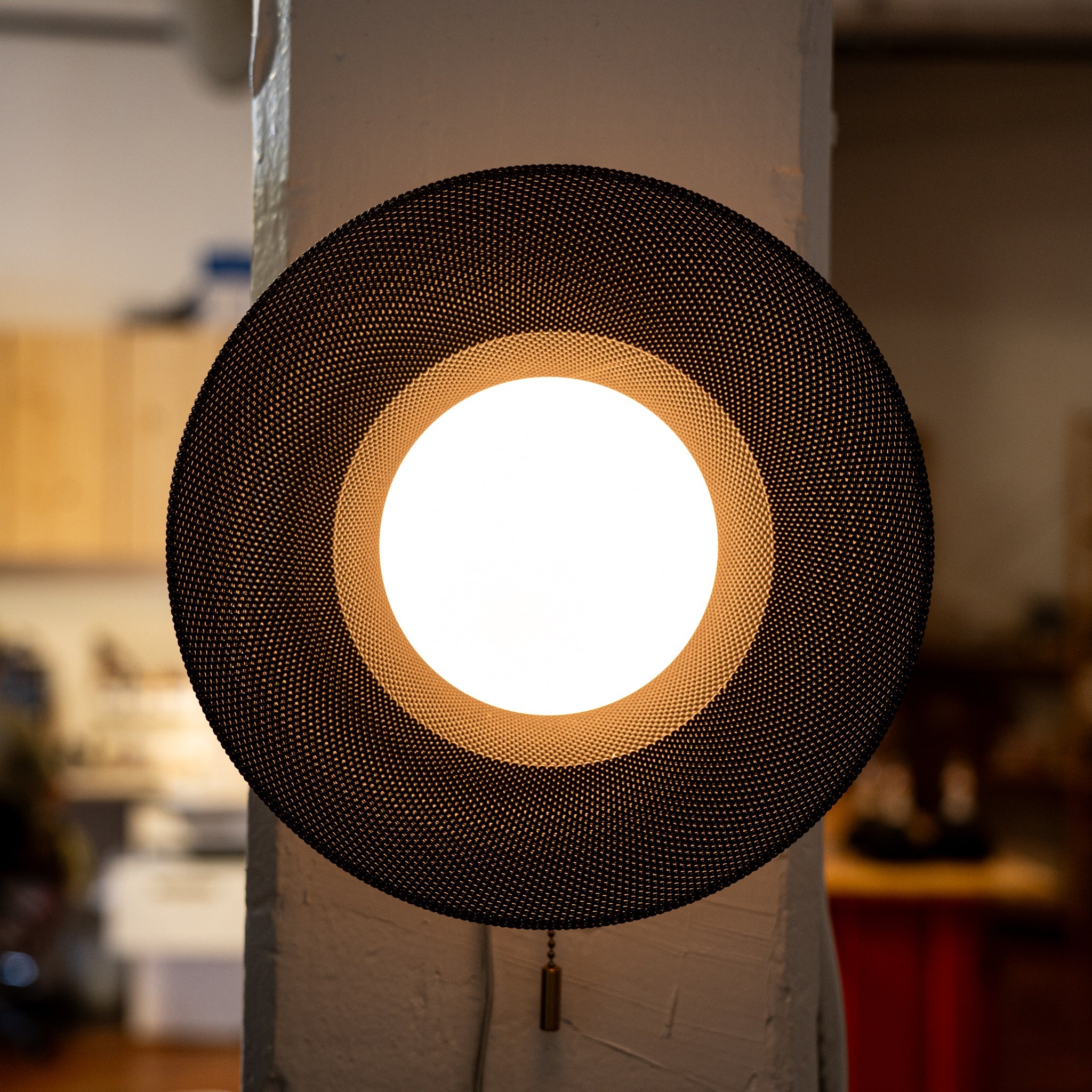 Round lamp with black woven design on a white background