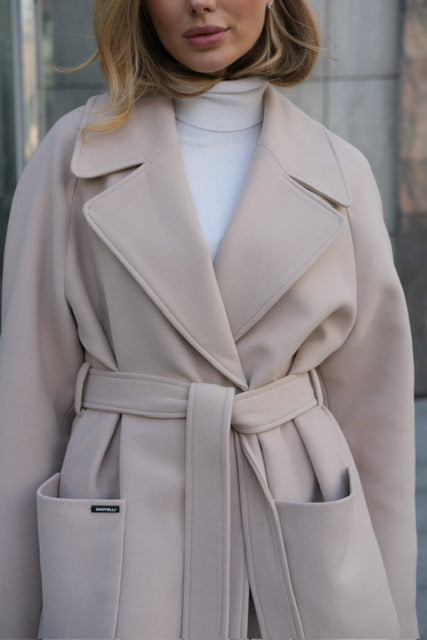 Beige trench coat worn by a person with a blurred background