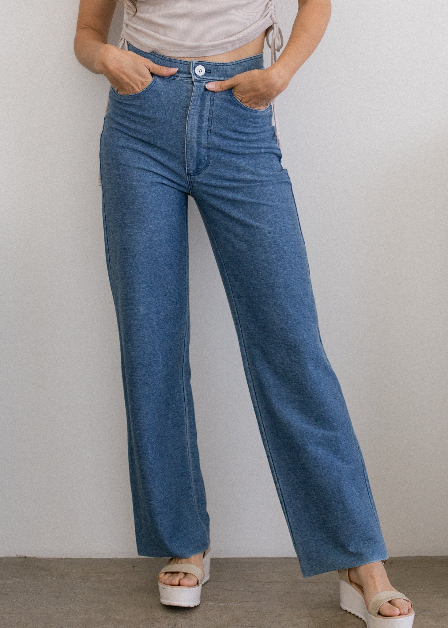 Person wearing blue jeans against a plain background