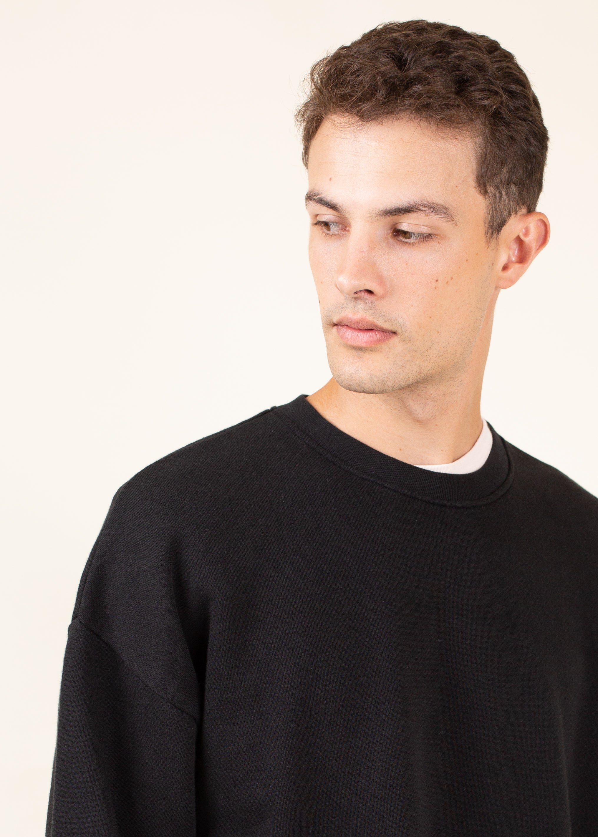 Man wearing a black sweater against a plain background