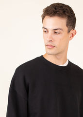 Man wearing a black sweater against a plain background