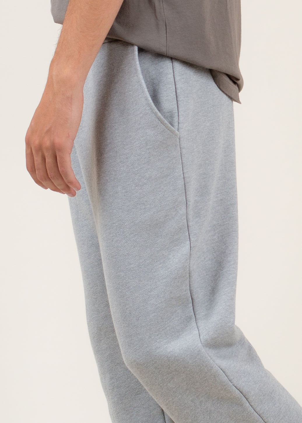 Gray sweatpants worn by a person on a light beige background