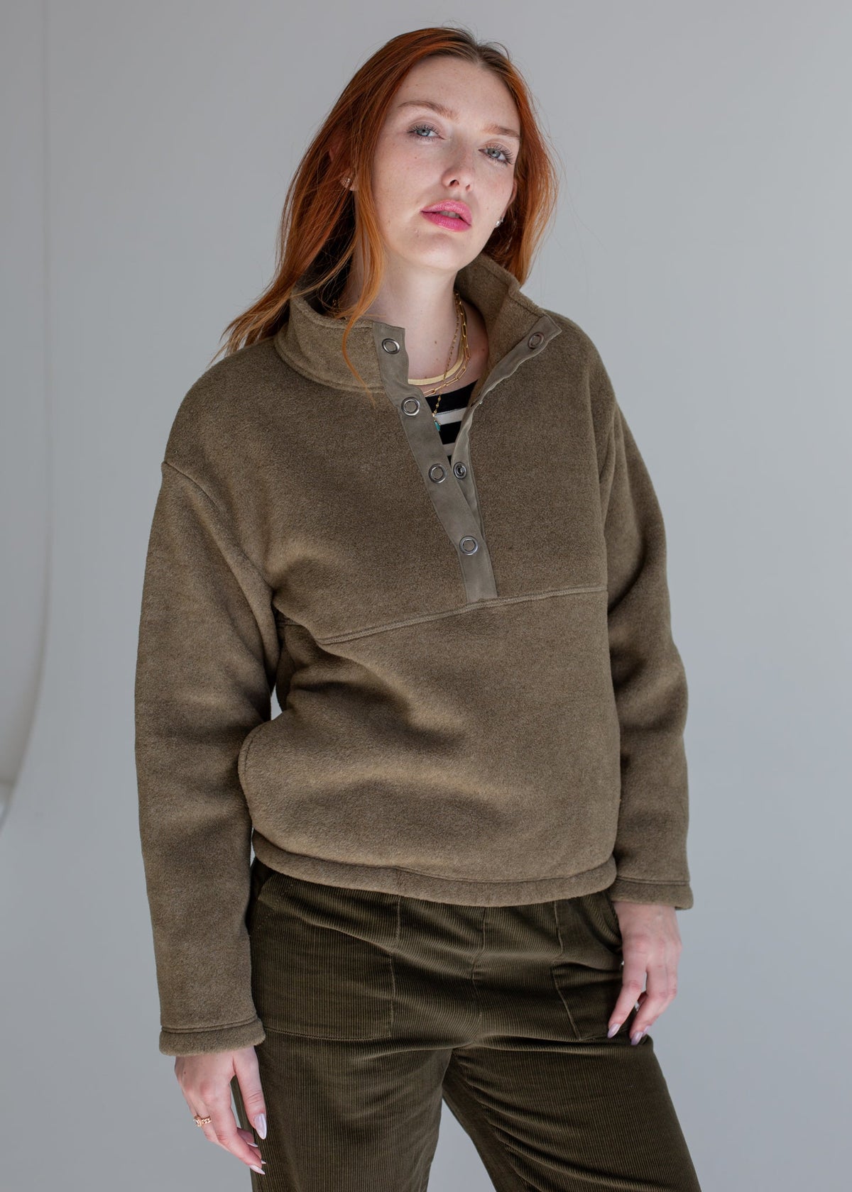 Person wearing a brown fleece pullover with a plain background