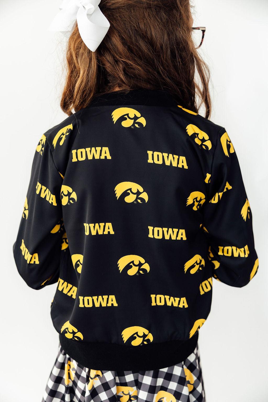 Black jacket with yellow 'Iowa' text and logos on a person against a white background