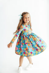 Young girl wearing a colorful floral dress on a white background