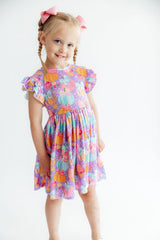 Young girl wearing a colorful floral dress on a white background