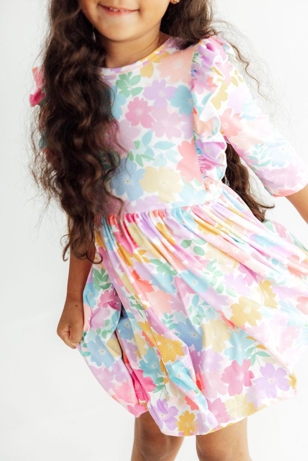 Child wearing a colorful floral dress on a white background