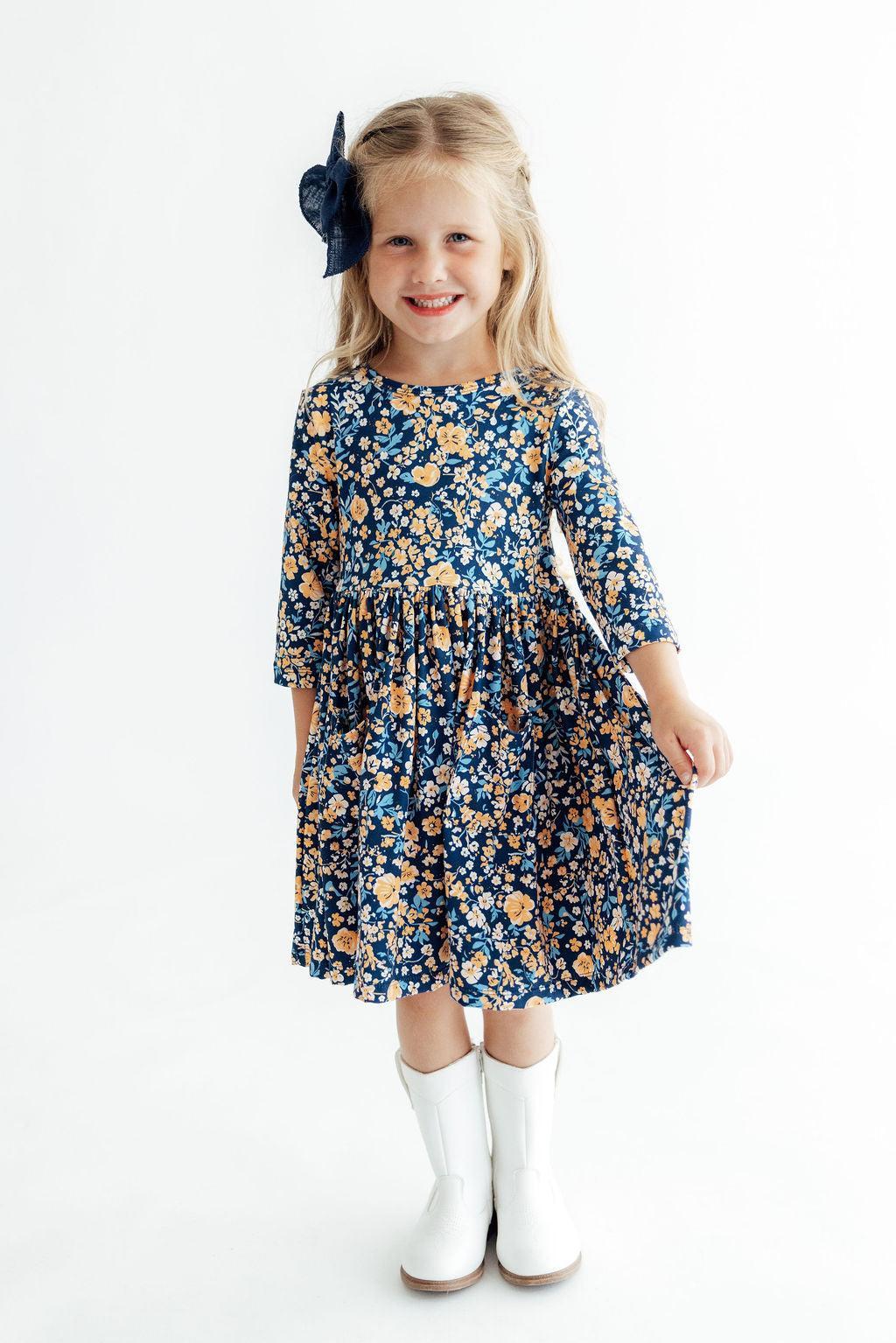 Young girl wearing a floral dress with a white background