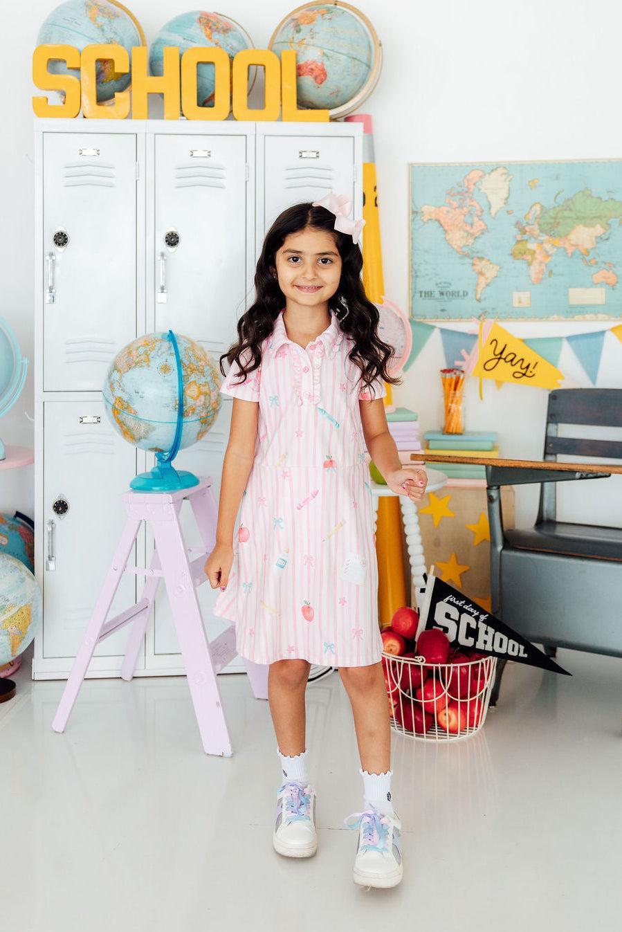 Young girl in a school-themed room with lockers, globes, and educational decor.