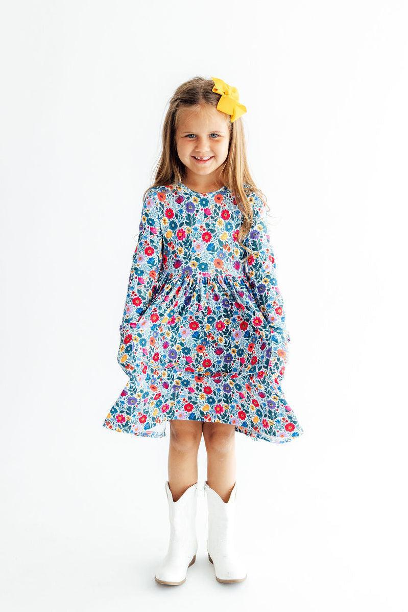 Young girl wearing a floral dress with white boots on a white background