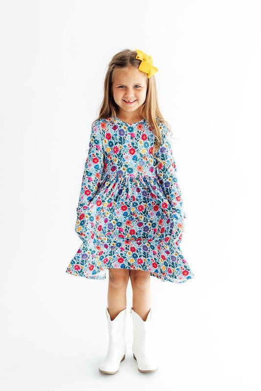 Young girl wearing a floral dress with white boots on a white background