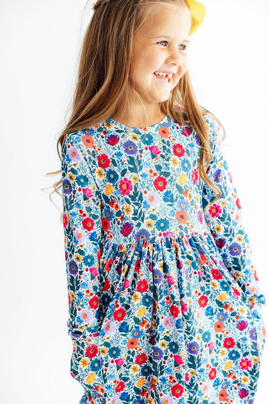 Young girl wearing a colorful floral dress on a white background