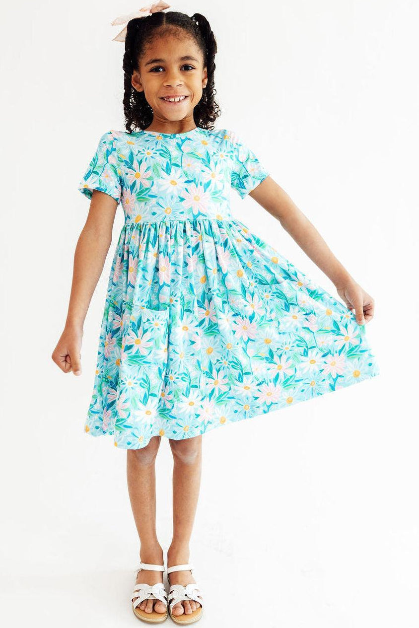 Young girl wearing a floral dress on a white background