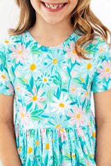 Child wearing a floral dress with a white background