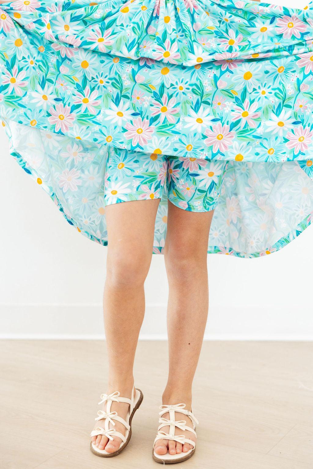 Person wearing a floral skirt with a white background