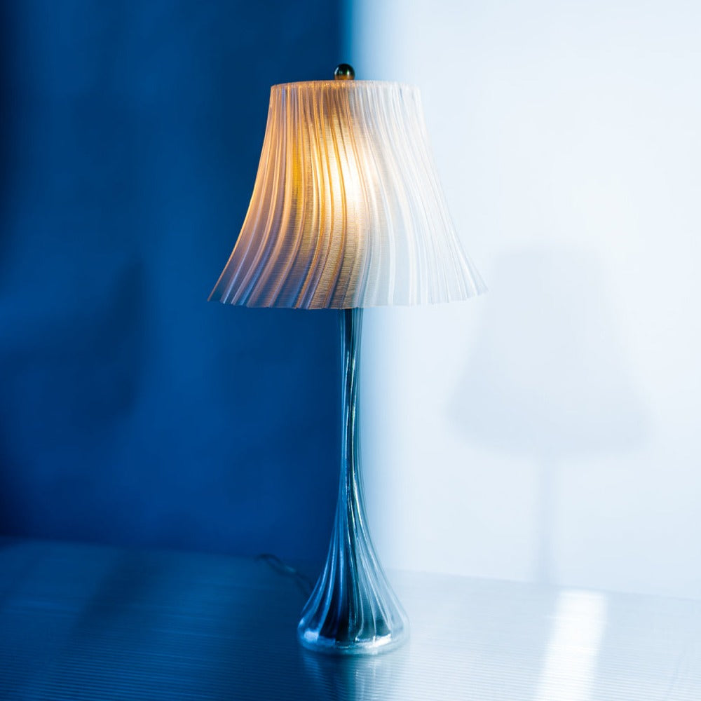 Decorative lamp with ribbed shade against a blue wall