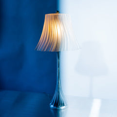 Decorative lamp with ribbed shade against a blue wall