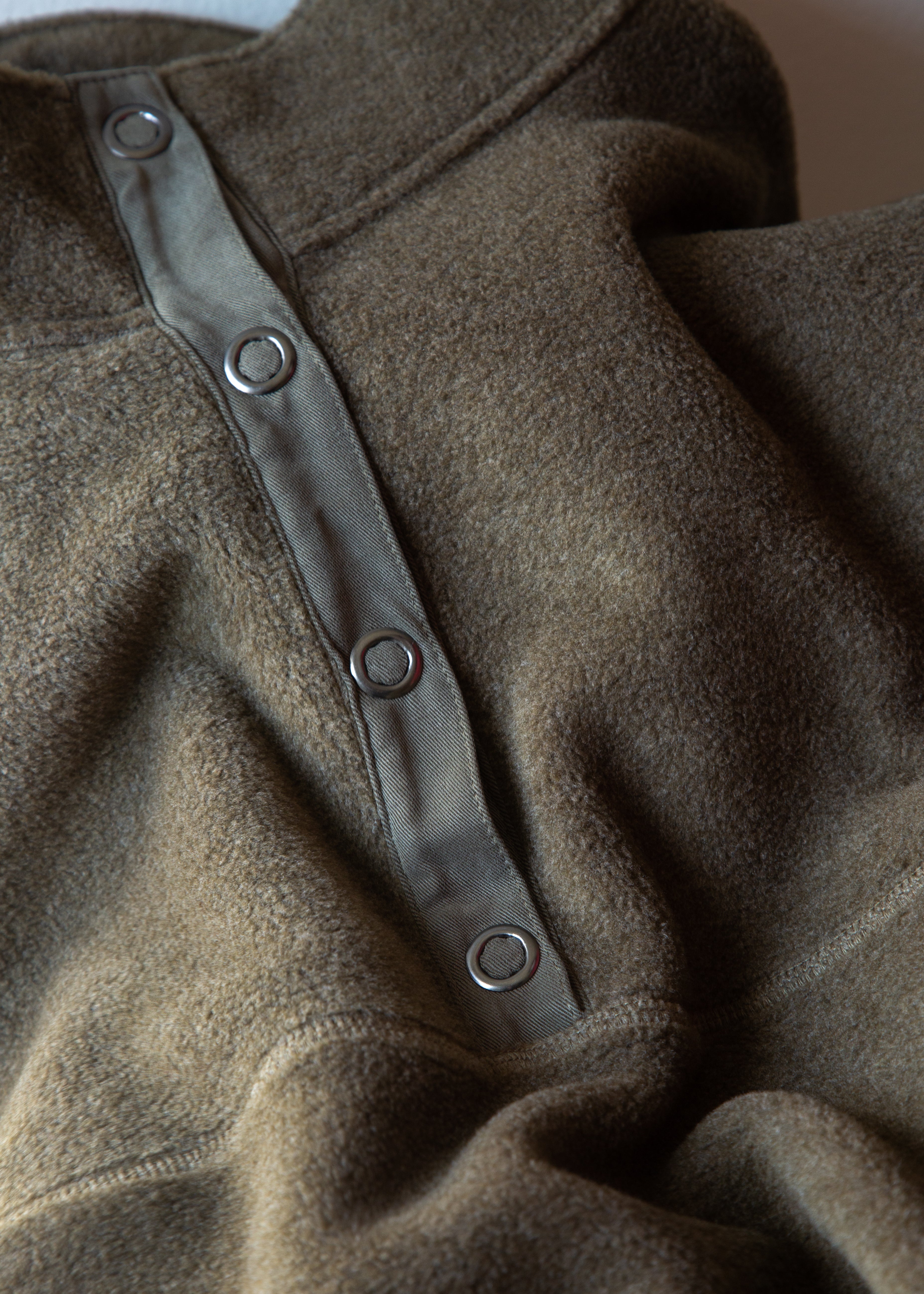 Close-up of a brown garment with button details