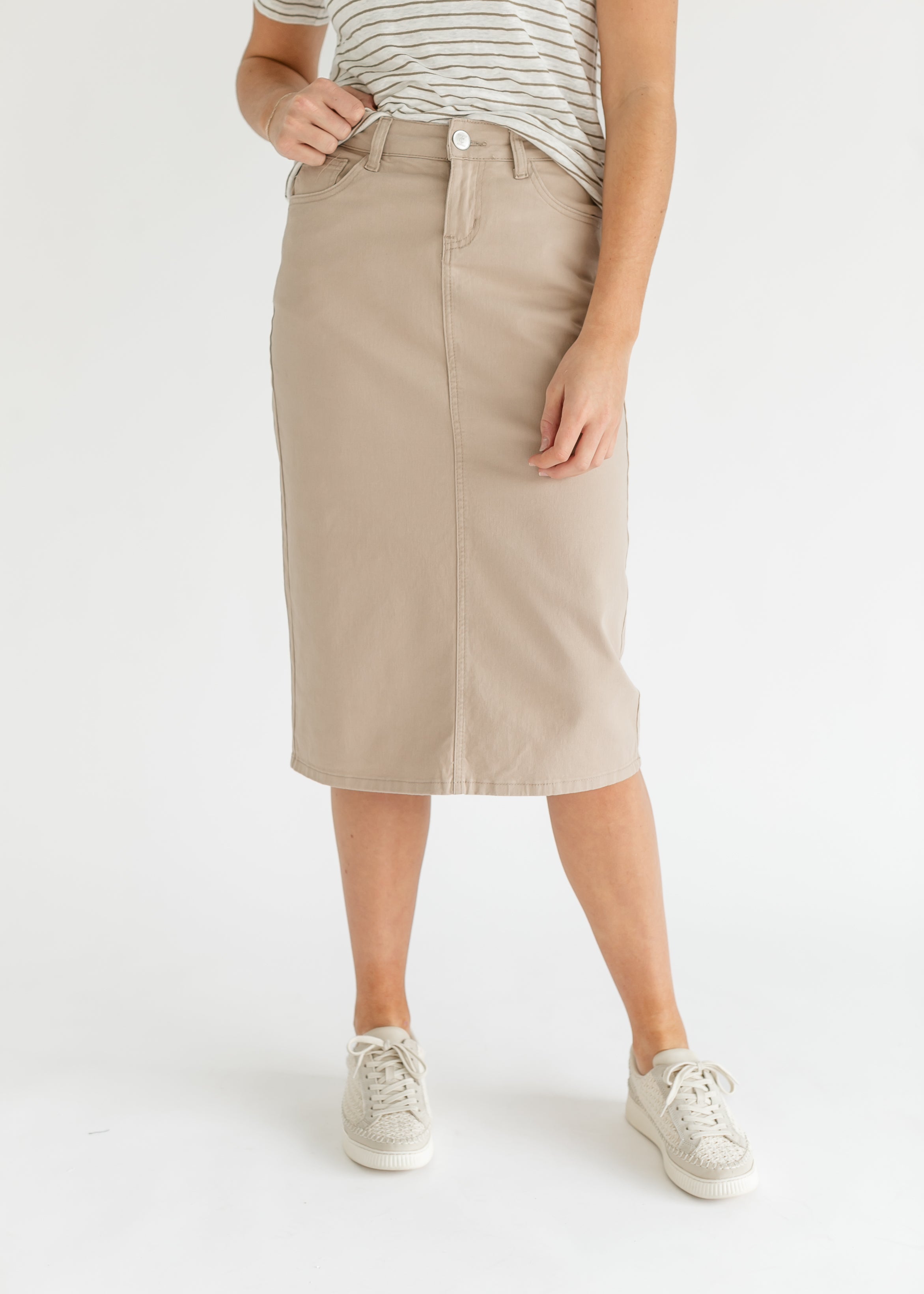 Person wearing a beige skirt with a white background