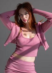 Woman wearing a pink outfit against a gray background