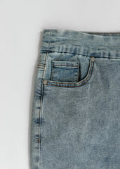 Close-up of a blue denim pocket on a white background