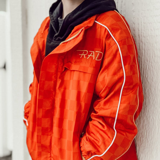 Orange checkered jacket with 'RAD' logo on a neutral background
